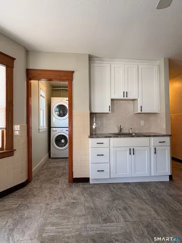 a kitchen with granite countertop a stove a sink and a refrigerator