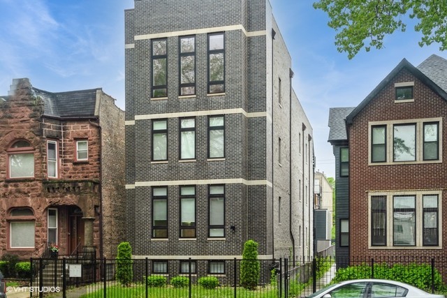 a front view of a residential apartment building with a yard