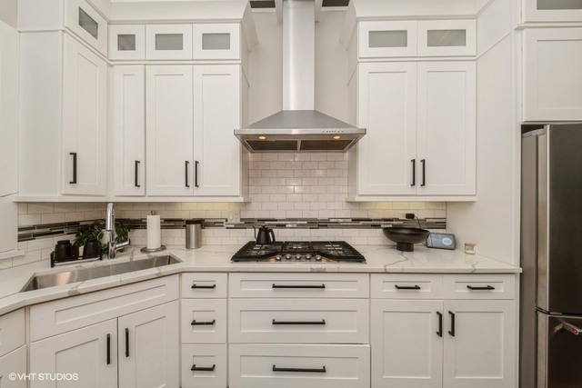 4730 South Champlain Avenue, Unit 3 Chicago, IL 60615 - Photo 7 of 16 a kitchen with white cabinets and a stove with wooden floor