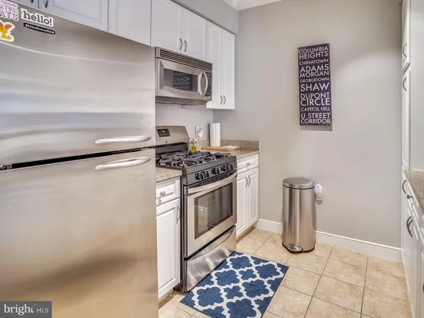a kitchen with granite countertop a stove top oven and cabinets