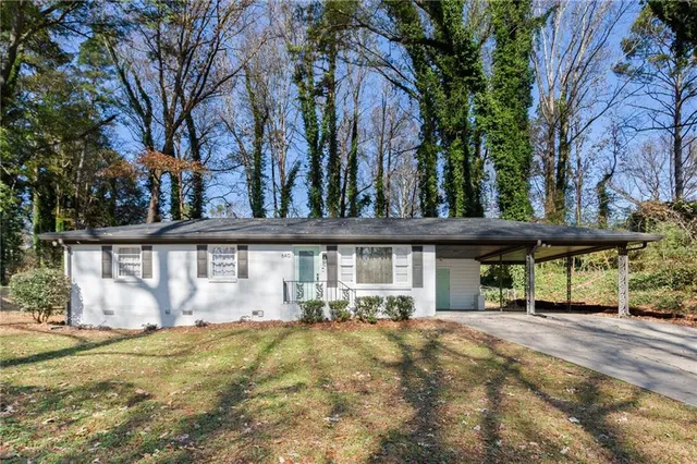 a front view of a house with a garden and tree