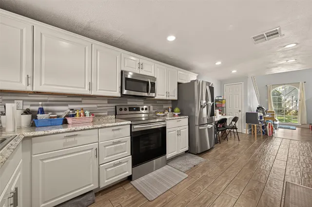 a kitchen with stainless steel appliances a stove top oven a sink dishwasher and a refrigerator