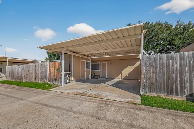 a view of a house with backyard and wooden fence