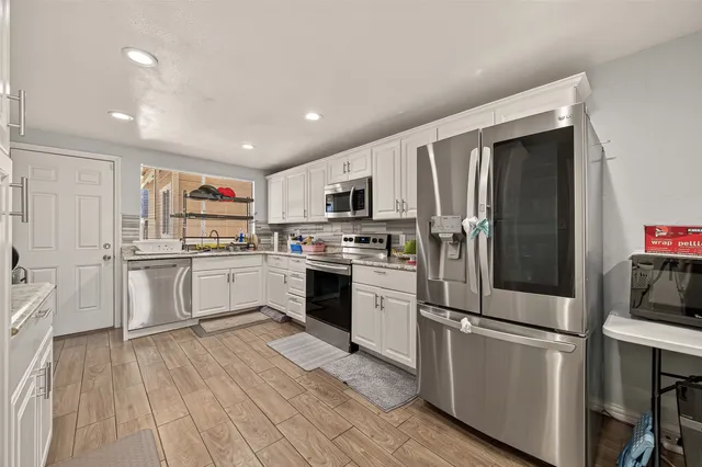 a kitchen with white cabinets stainless steel appliances and sink