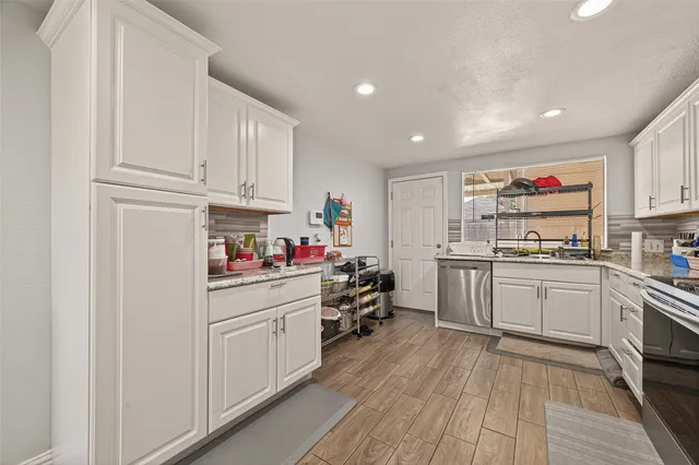 a kitchen with cabinets and wooden floor