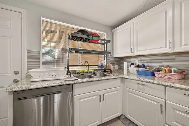 a kitchen with stainless steel appliances granite countertop a sink dishwasher window and cabinets