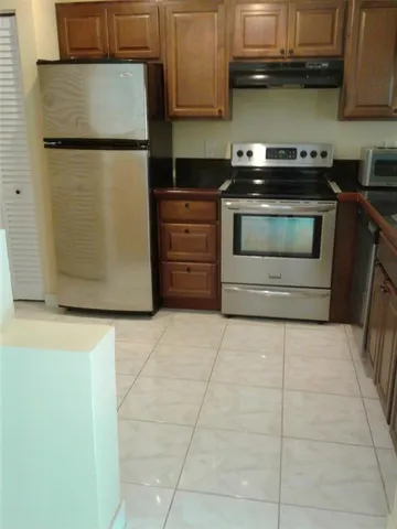 a kitchen with granite countertop a stove and a refrigerator