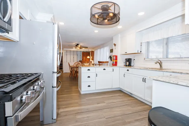 a kitchen with a stove cabinets and wooden floor