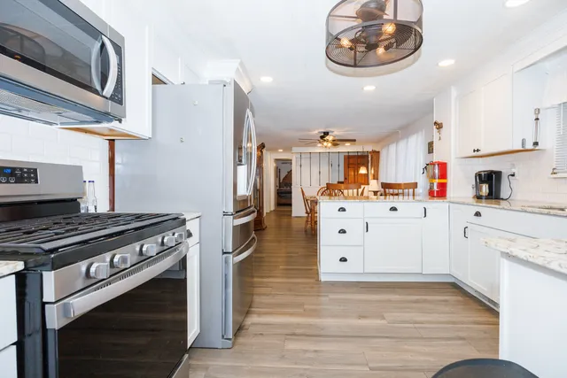 a kitchen with stainless steel appliances a white stove top oven and cabinets