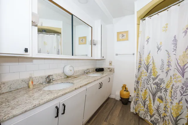 a bathroom with a granite countertop sink and a mirror