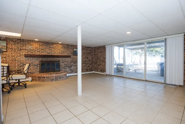 a view of a livingroom with a fireplace and window