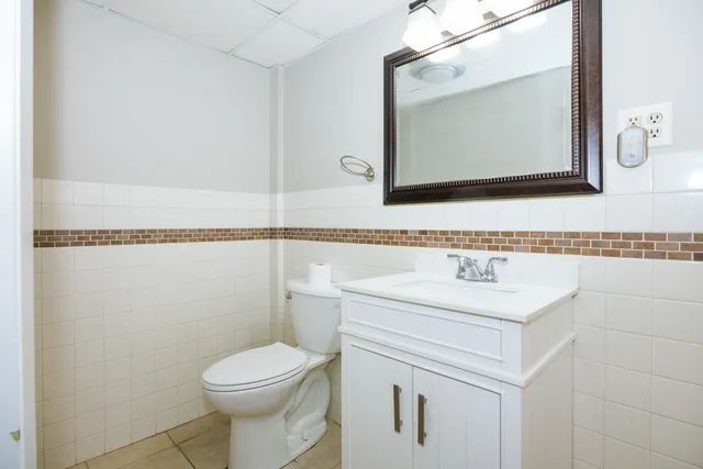 a bathroom with a toilet sink and mirror