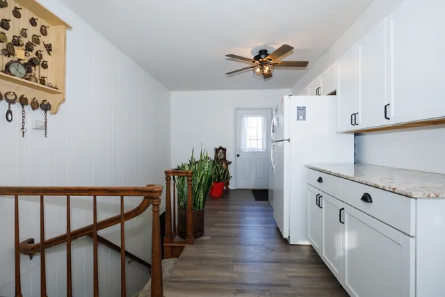 a view of a hallway with wooden floor and staircase