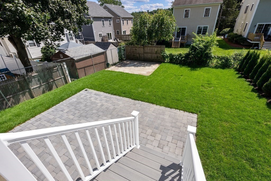 38 Gregory Street Waltham, MA 02451 - Photo 20 of 21 a view of a backyard with couches plants and a fire pit