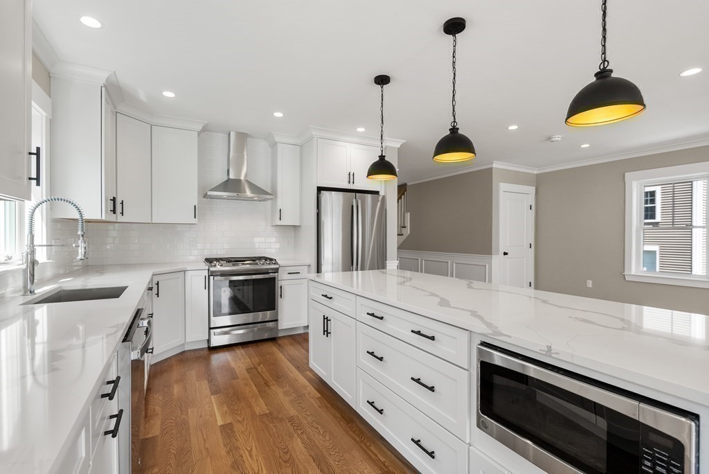 38 Gregory Street Waltham, MA 02451 - Photo 6 of 21 a kitchen with stainless steel appliances granite countertop a sink a stove and a wooden floors