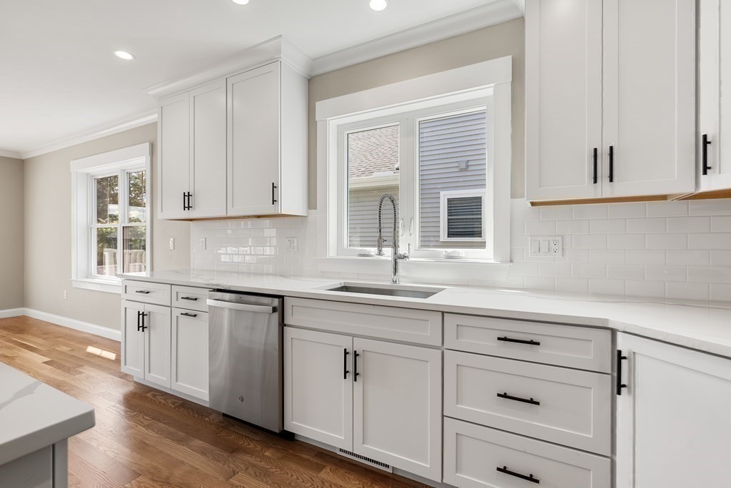 38 Gregory Street Waltham, MA 02451 - Photo 9 of 21 a kitchen with granite countertop white cabinets and white appliances