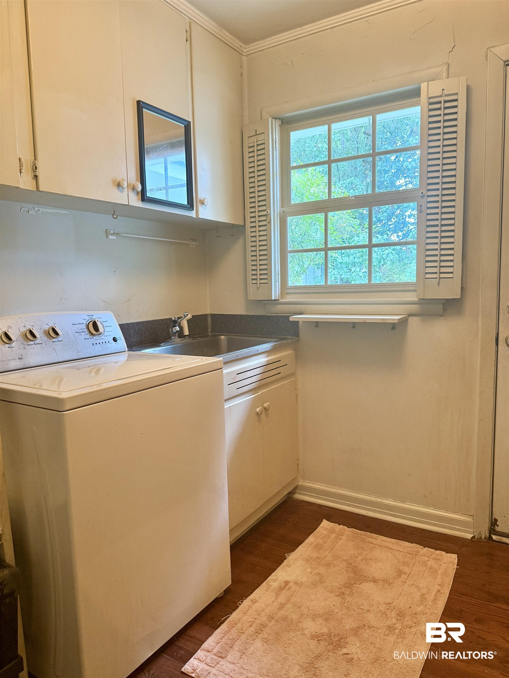 1412 Poplar Avenue Brewton, AL 36426 - Photo 24 of 32 Washroom featuring washer / dryer, cabinet space, dark wood finished floors, and crown molding