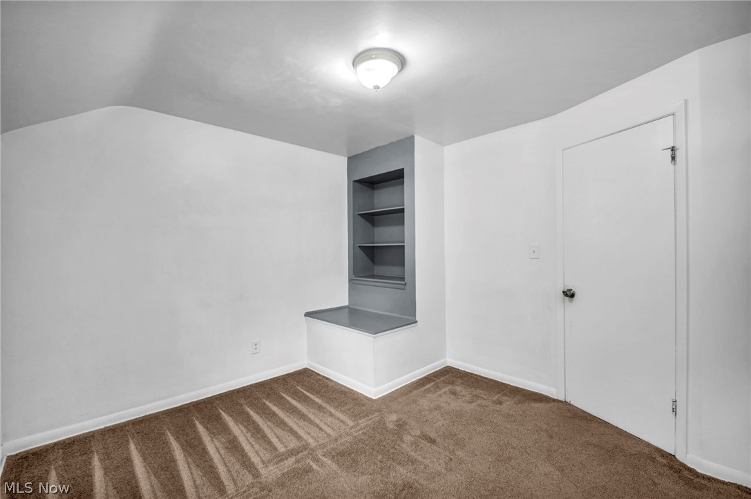 2313 North Taylor Road Cleveland Heights, OH 44112 - Photo 20 of 32 Room featuring a built-in shelving unit with a lower bench, neutral wall paint, and brown carpet flooring