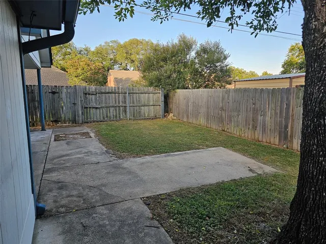 a view of backyard with wooden fence