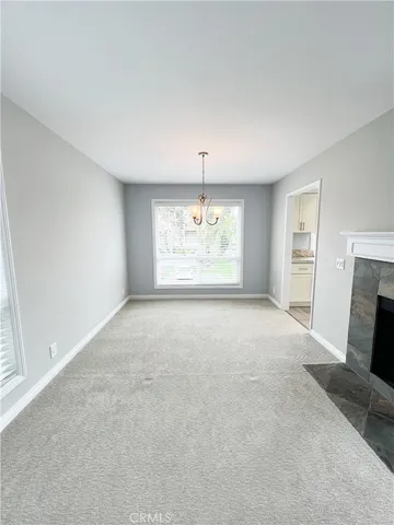 an empty room with windows and fireplace