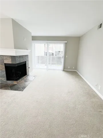 an empty room with windows and fireplace