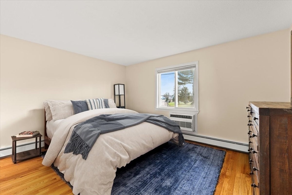 39 Will Drive, Unit 16 Canton, MA 02021 - Photo 6 of 13 a bedroom with a bed and wooden floor