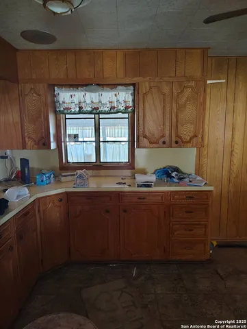 a kitchen with kitchen island granite countertop a sink stove and cabinets