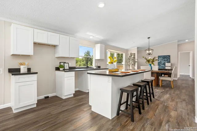 a kitchen with a table chairs refrigerator and cabinets