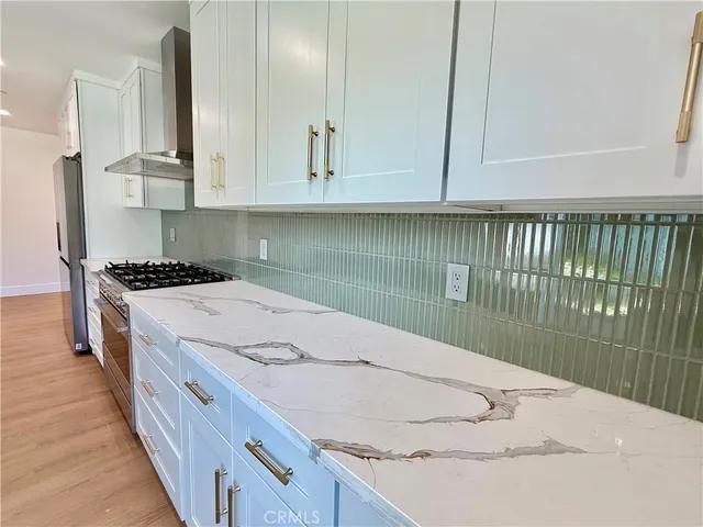 a kitchen with granite countertop a sink a stove and cabinets