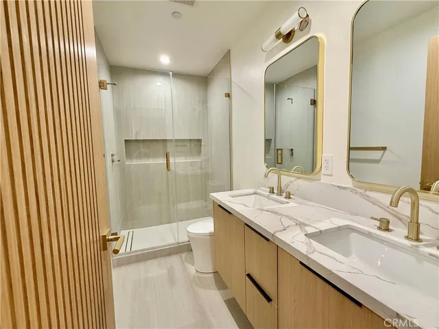 a bathroom with a sink and mirror with toilet
