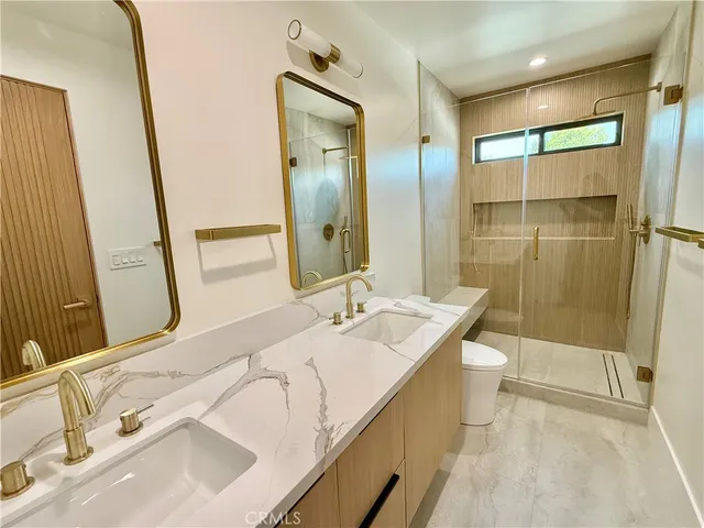 a bathroom with a sink and mirror with toilet