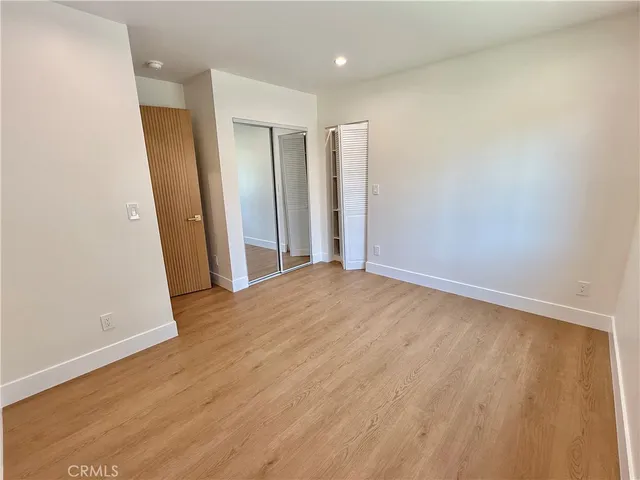 an empty room with wooden floor and entrance