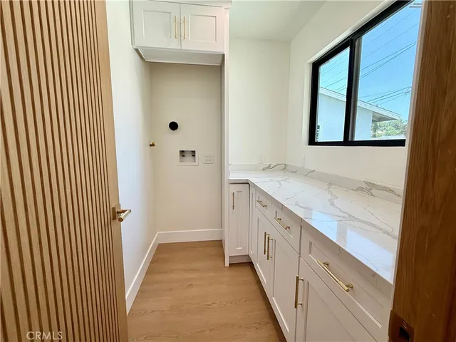 a bathroom with a granite countertop sink and a window