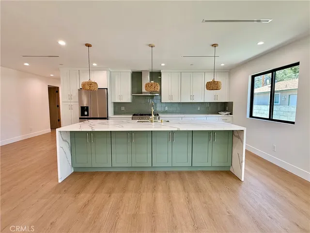 a kitchen with kitchen island granite countertop a sink window and cabinets