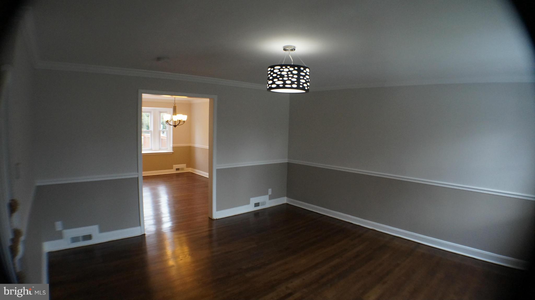 1604 Pentwood Road Baltimore, MD 21239 - Photo 3 of 14 an empty room with wooden floor and windows