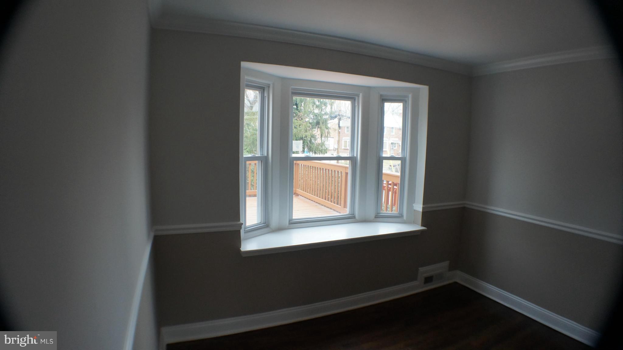 1604 Pentwood Road Baltimore, MD 21239 - Photo 5 of 14 a view of an empty room with wooden floor and a window