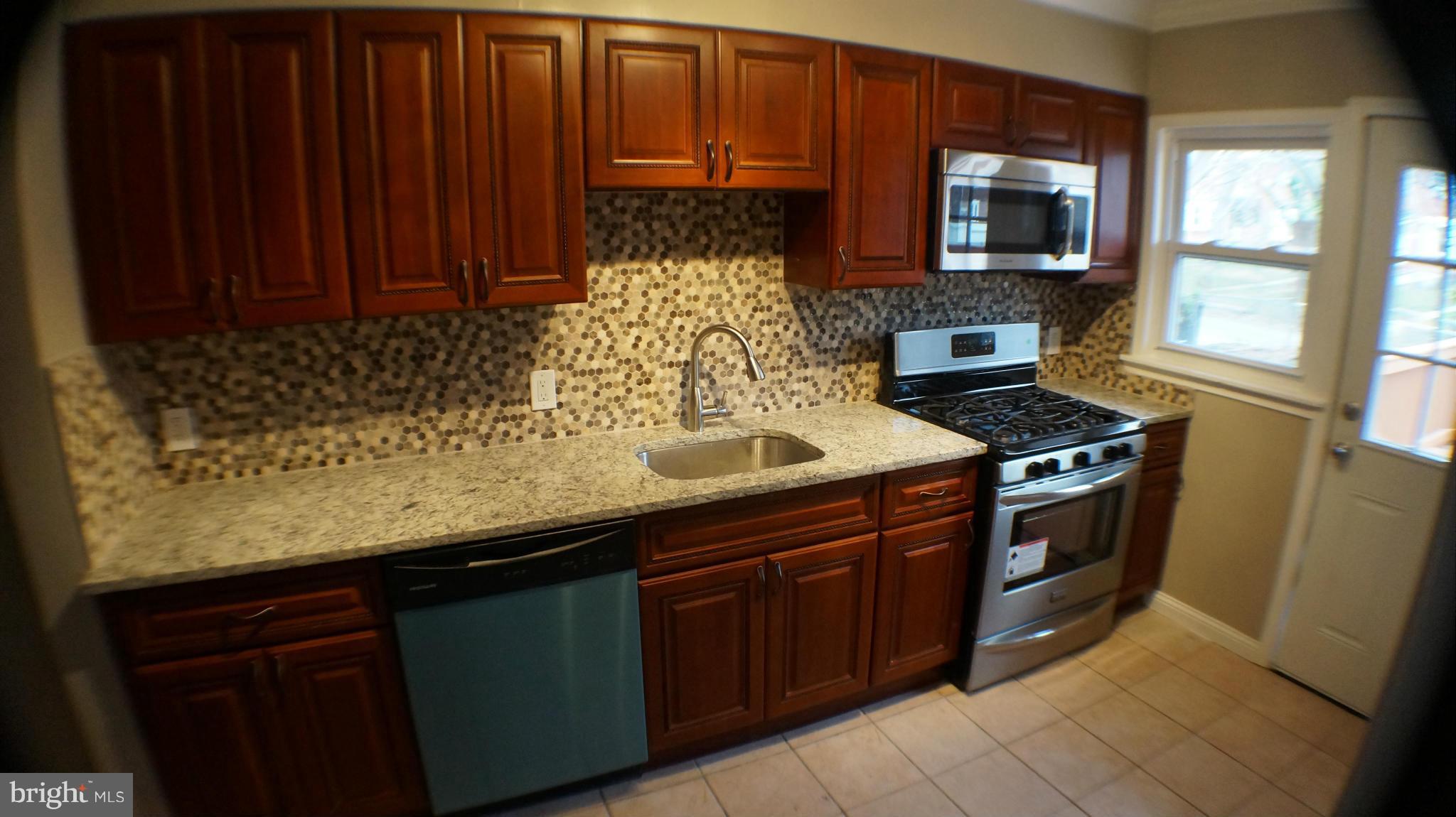 1604 Pentwood Road Baltimore, MD 21239 - Photo 6 of 14 a kitchen with stainless steel appliances granite countertop a sink stove and microwave