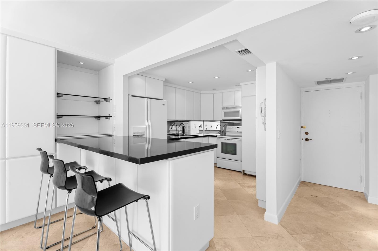 1901 Brickell Avenue, Unit B407 Miami, FL 33129 - Photo 4 of 27 a kitchen with kitchen island a counter top space a sink stainless steel appliances and cabinets