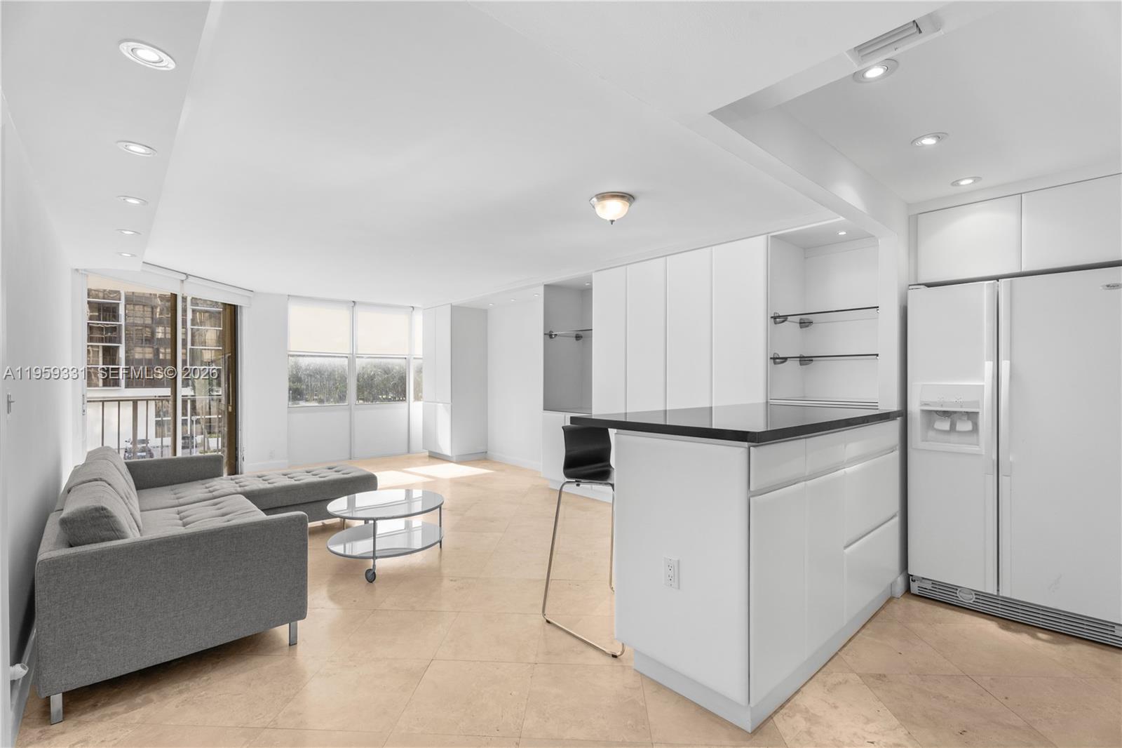 1901 Brickell Avenue, Unit B407 Miami, FL 33129 - Photo 5 of 27 a living room with kitchen island furniture and a large window