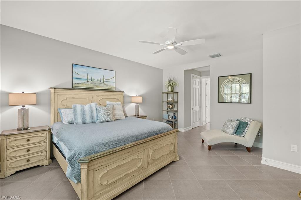 14671 Topsail Drive Naples, FL 34114 - Photo 11 of 36 a bedroom with a bed and a chandelier