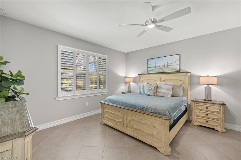 14671 Topsail Drive Naples, FL 34114 - Photo 12 of 36 a bedroom with a bed a chandelier and a window