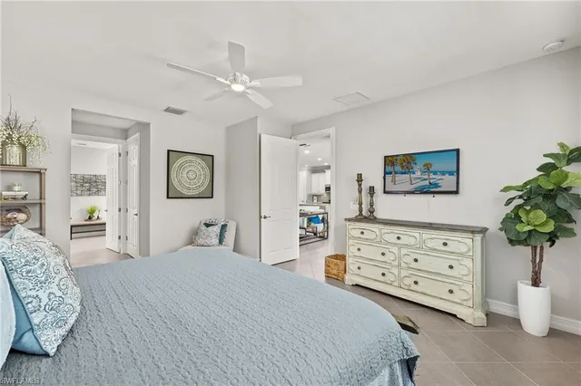 a bedroom with a bed a dresser and painting on the wall