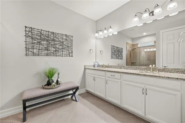 a spacious bathroom with a granite countertop sink a mirror and a potted plant