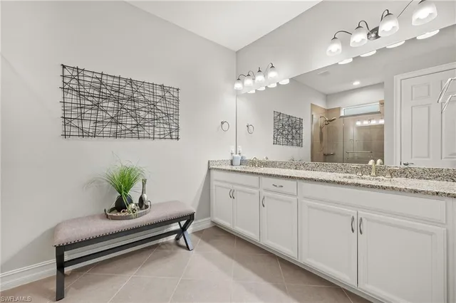 a spacious bathroom with a granite countertop sink a mirror and a potted plant