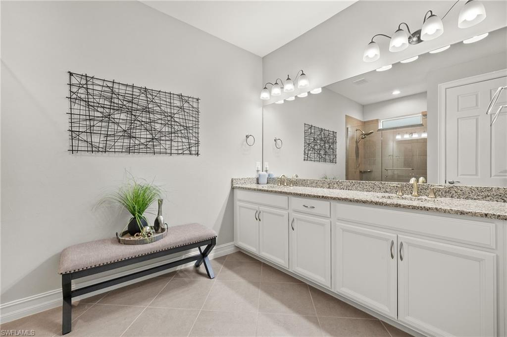 14671 Topsail Drive Naples, FL 34114 - Photo 14 of 36 a spacious bathroom with a granite countertop sink a mirror and a potted plant