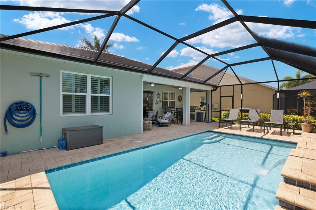 14671 Topsail Drive Naples, FL 34114 - Photo 22 of 36 a view of a backyard with table and chairs under an umbrella
