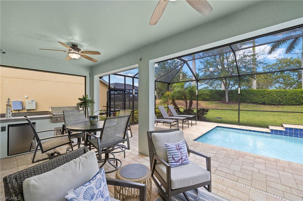 14671 Topsail Drive Naples, FL 34114 - Photo 24 of 36 a living room with furniture and a floor to ceiling window