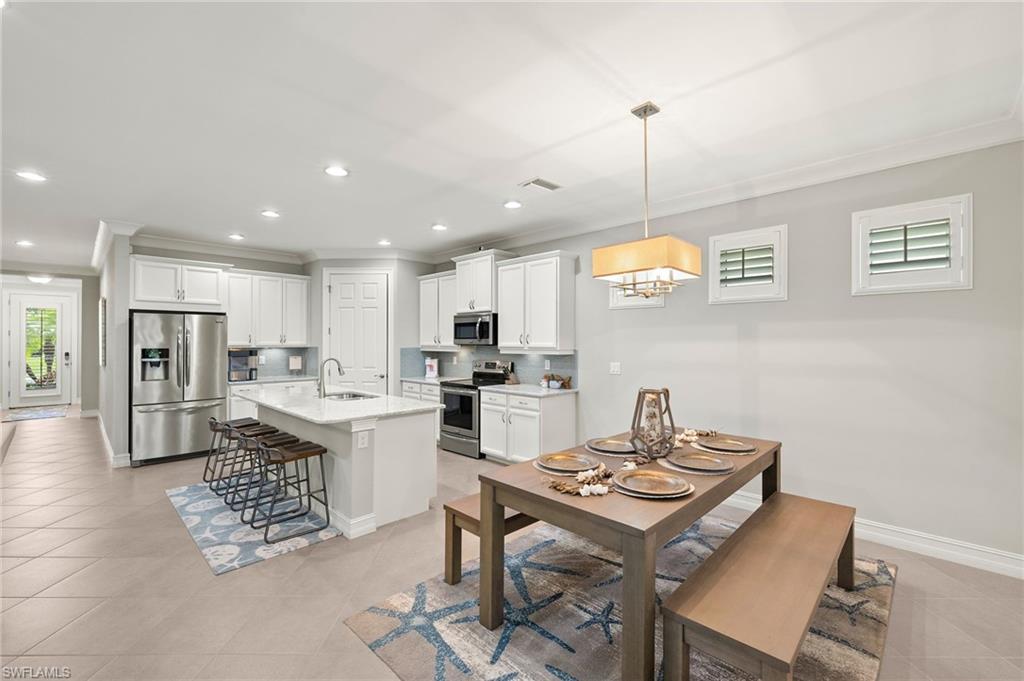 14671 Topsail Drive Naples, FL 34114 - Photo 3 of 36 a kitchen with a table and chairs in it