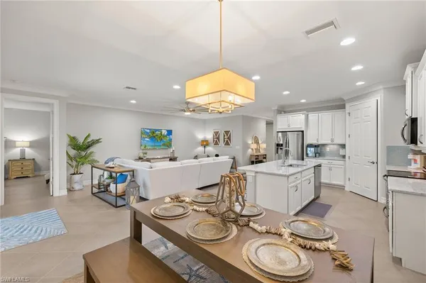 a living room with furniture and a dining table with kitchen view