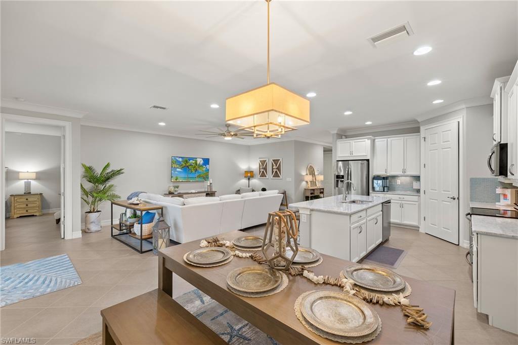 14671 Topsail Drive Naples, FL 34114 - Photo 4 of 36 a living room with furniture and a dining table with kitchen view